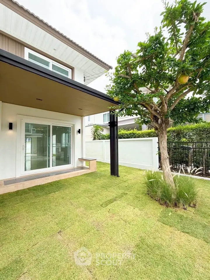 Charming modern home with lush green garden and patio, perfect for outdoor relaxation.