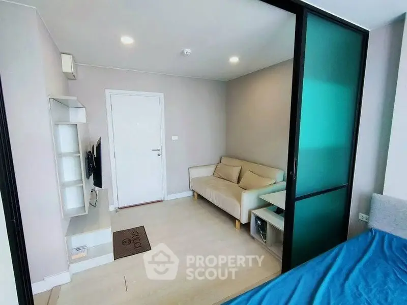 Modern living room with sliding glass door and cozy sofa in a stylish apartment.