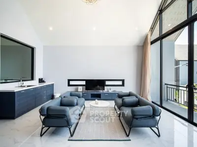 Spacious modern living room with sleek furniture and large windows offering natural light.