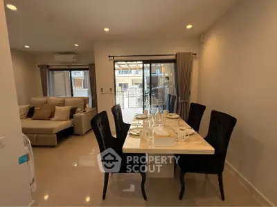 Modern dining area with elegant table setting and cozy living room view