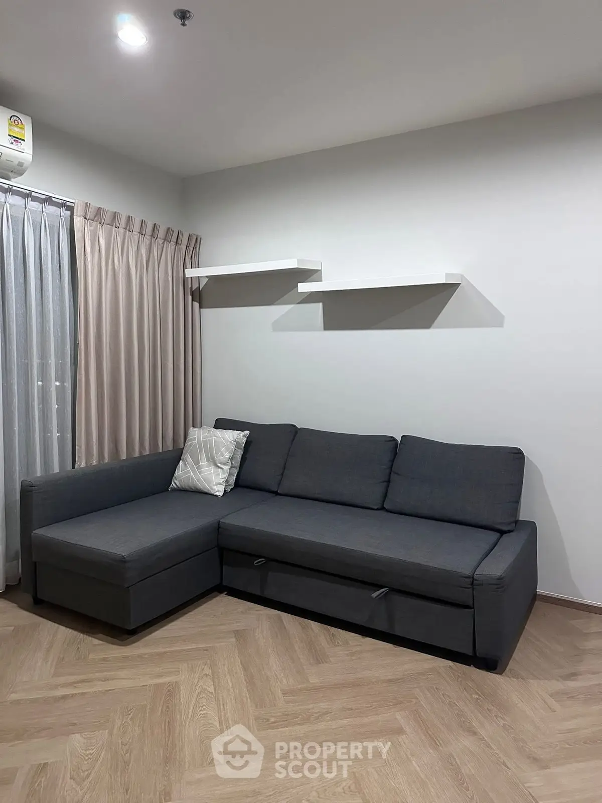 Modern living room with stylish gray sectional sofa and elegant wooden flooring