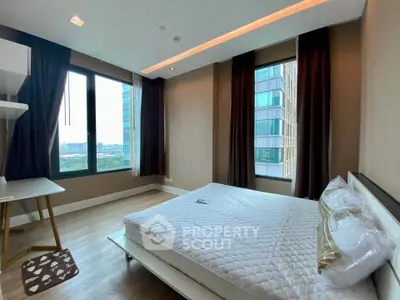 Modern bedroom with large windows and city view in a high-rise apartment.