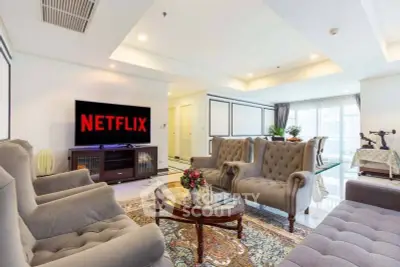 Luxurious living room with elegant furniture and large TV, perfect for entertainment and relaxation.