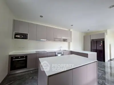 Modern kitchen with sleek cabinetry, island, and built-in appliances in a spacious layout.