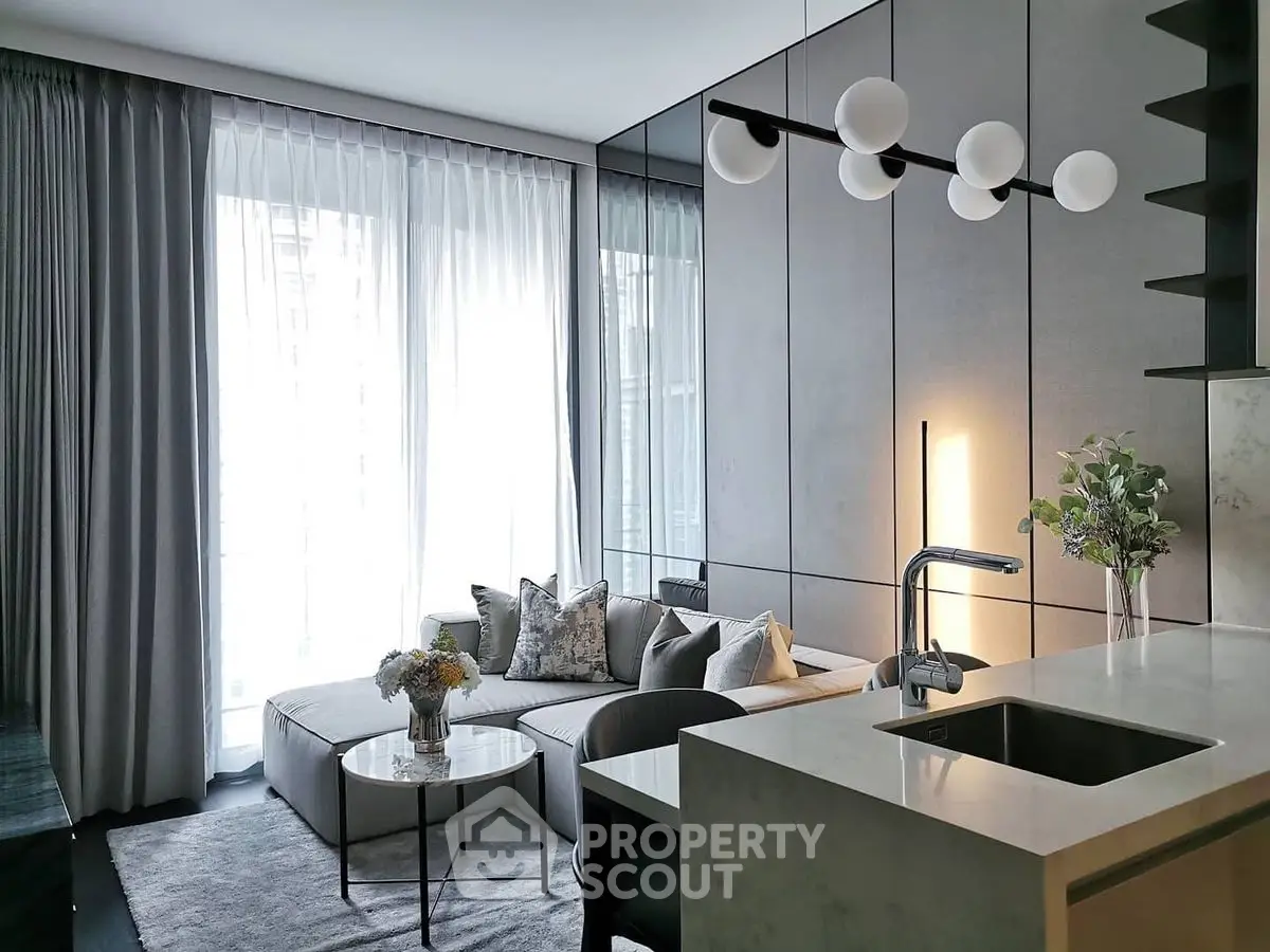 Modern living room with sleek design, featuring a cozy sofa, elegant lighting, and a stylish open kitchen.