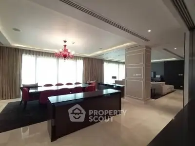 Luxurious open-plan living and dining area with elegant chandelier and modern furnishings.