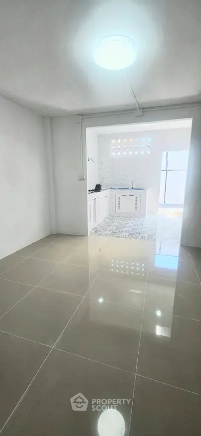 Spacious open-plan kitchen with sleek tile flooring and modern fixtures