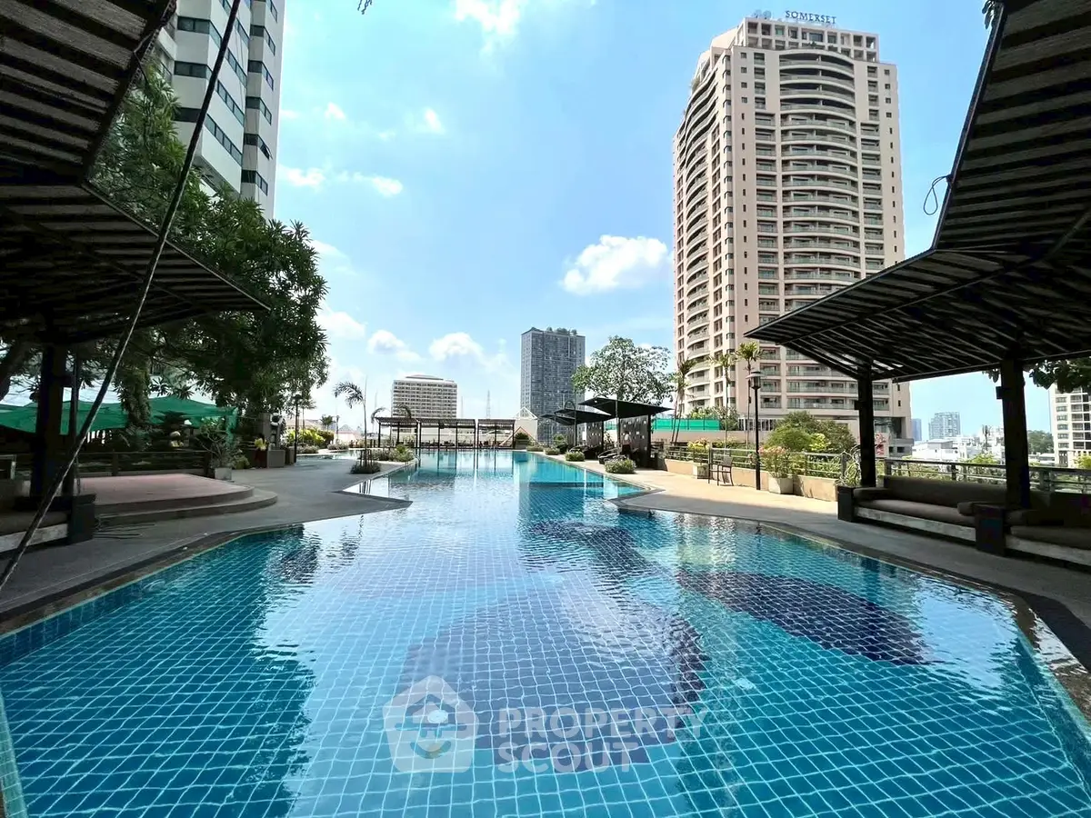 Luxurious rooftop pool with stunning city views in a high-rise building complex.