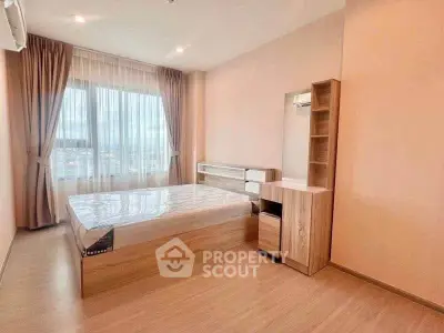 Spacious bedroom with large window and modern wooden furniture