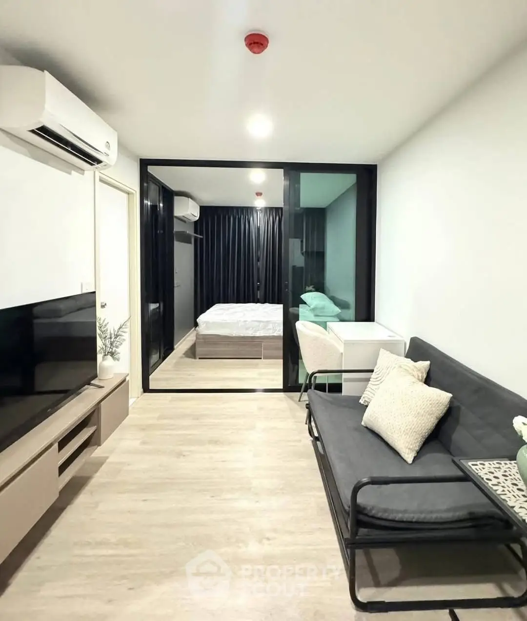 Modern living room with sleek design and view into cozy bedroom