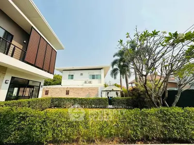 Modern two-story house with lush garden and contemporary design in a serene neighborhood.