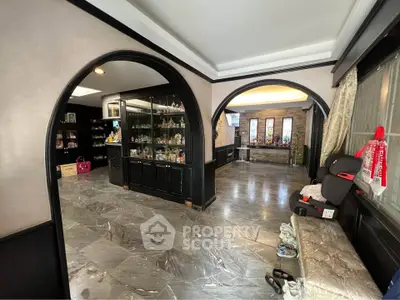 Spacious interior with elegant arches and marble flooring, showcasing a luxurious living area.
