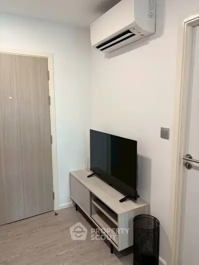 Modern living room with sleek TV stand and air conditioning unit, perfect for cozy urban living.