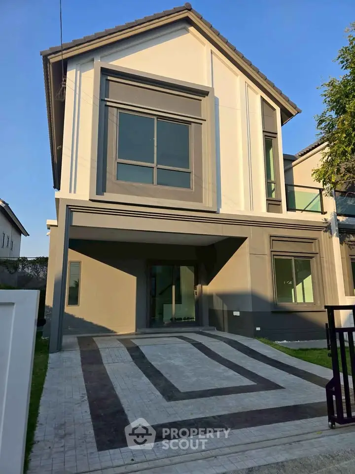 Modern two-story house with sleek design and spacious driveway in a serene neighborhood.
