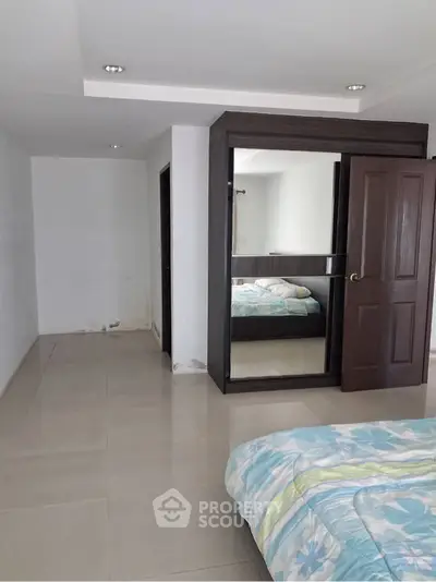 Spacious bedroom with modern design and large mirror wardrobe
