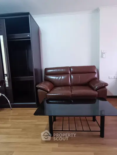 Cozy living room with brown leather sofa and glass coffee table