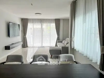 Spacious modern living room with large windows and elegant furnishings
