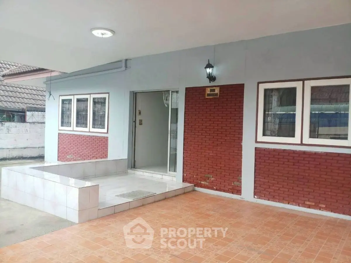 Charming exterior with brick accents and tiled patio, perfect for welcoming guests.