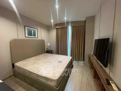 Modern bedroom with large bed, stylish decor, and natural light from window.
