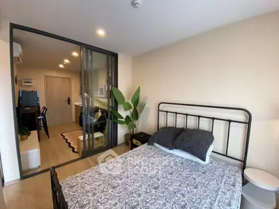 Modern bedroom with sliding glass doors and stylish decor in a cozy apartment.