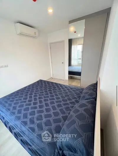 Modern bedroom with stylish bedding and mirrored wardrobe in a contemporary apartment.