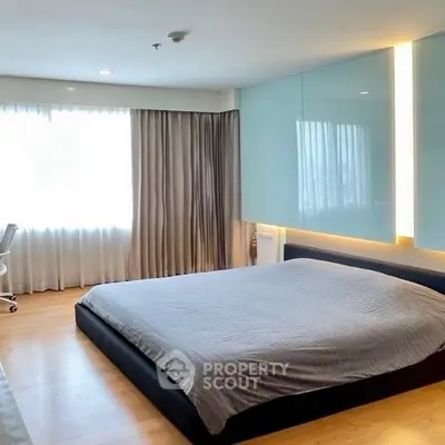 Spacious bedroom with modern design and large window for natural light.