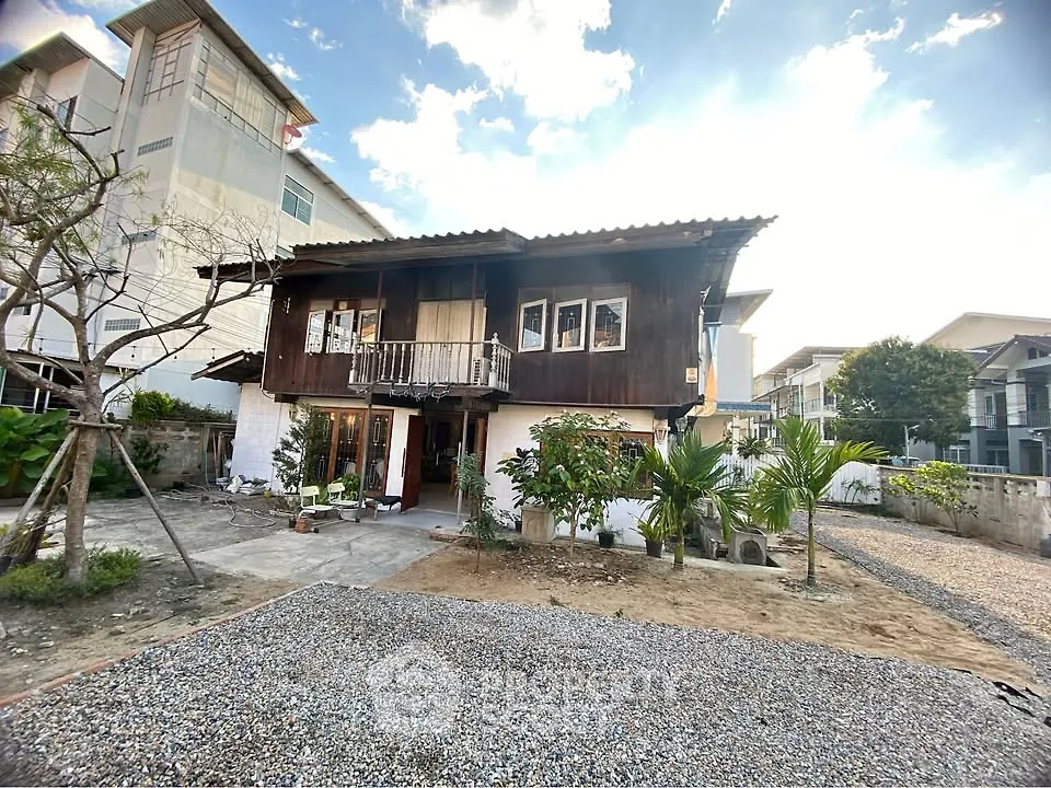 Charming rustic wooden house with spacious garden and gravel driveway, perfect for serene living.