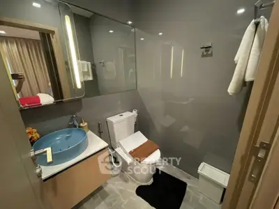 Modern bathroom with sleek design, featuring a stylish blue basin and elegant fixtures.