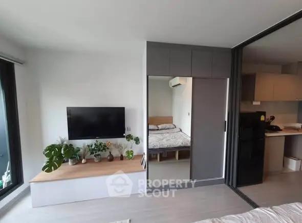 Modern apartment interior with sleek design and open layout, featuring a cozy bedroom and stylish living area.