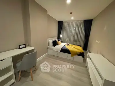 Modern bedroom with stylish decor and workspace, featuring cozy bed and sleek furniture.