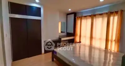 Spacious bedroom with modern design and ample natural light from large windows.