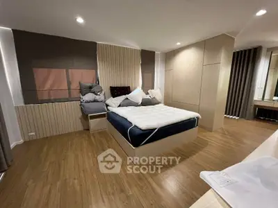 Spacious modern bedroom with wooden flooring and stylish decor