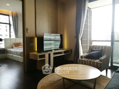 Modern living room with TV, striped armchair, and view of bedroom in luxury apartment.