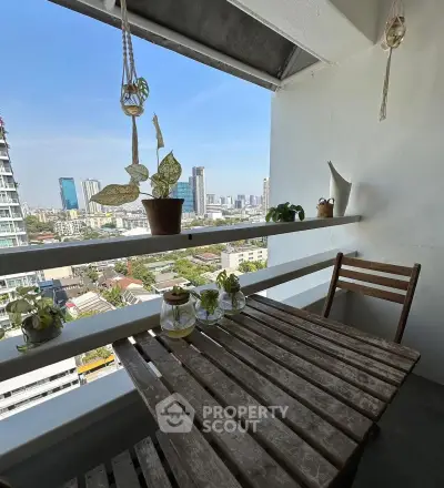 Charming balcony with city view, featuring rustic wooden table and plants, perfect for relaxation.