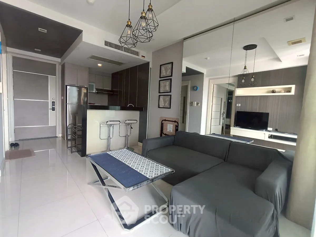 Modern living room with sleek furniture and open kitchen layout in a stylish apartment.