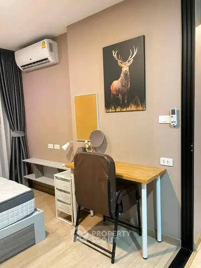 Cozy bedroom with study area featuring a desk, chair, and wall art, ideal for modern living.