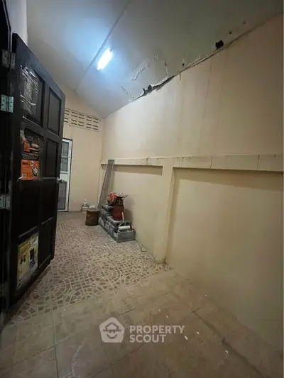 Spacious storage room with tiled floor and ample lighting, perfect for organizing household items.