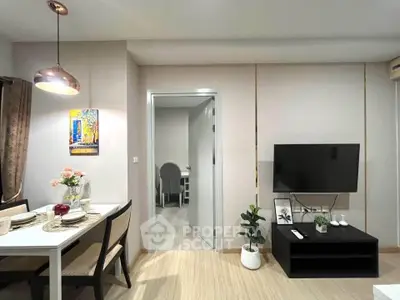 Modern living room with dining area, stylish decor, and wall-mounted TV in a cozy apartment.