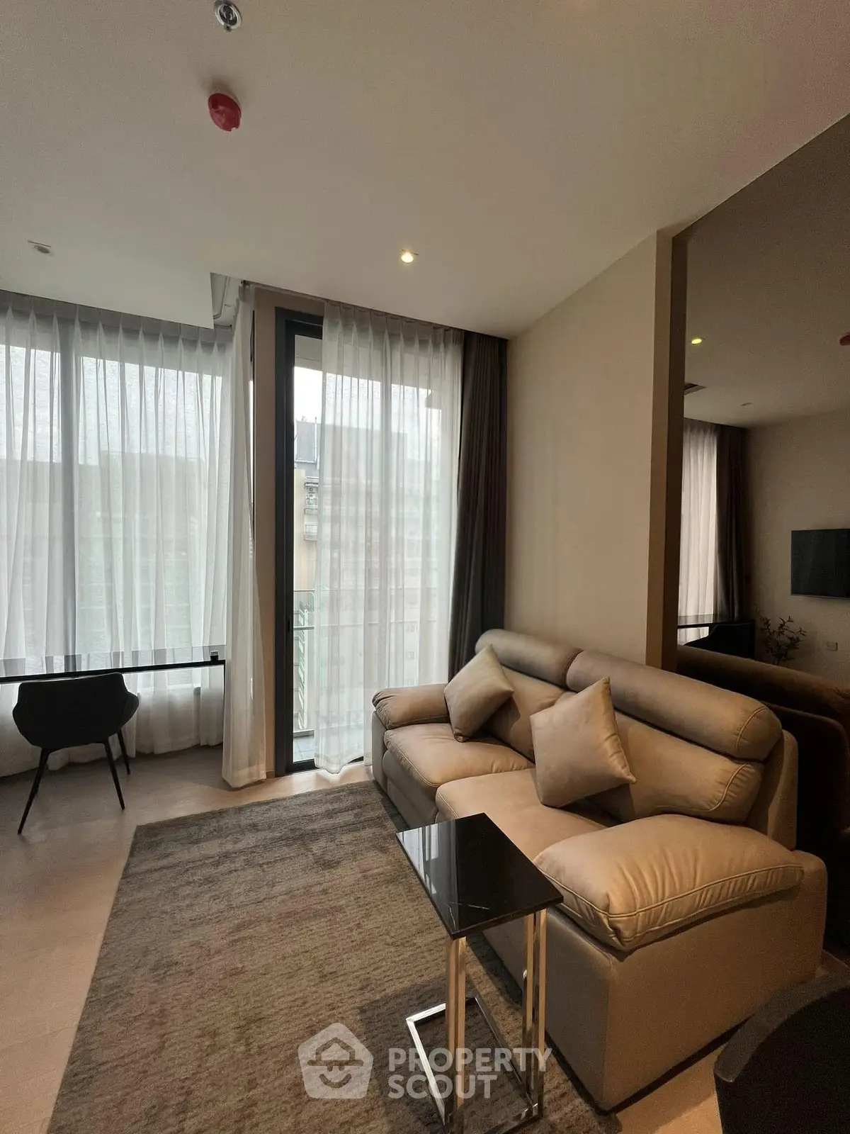 Modern living room with stylish sofa and large windows in a contemporary apartment.