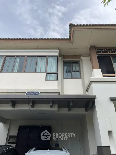 Modern two-story house exterior with carport and large windows