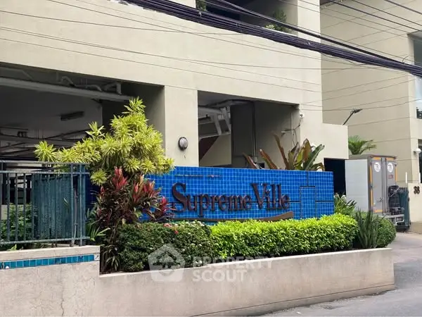 Elegant entrance of Supreme Ville with lush greenery and modern design.