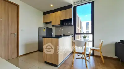 Modern kitchen with sleek wooden cabinets and dining area in a bright apartment