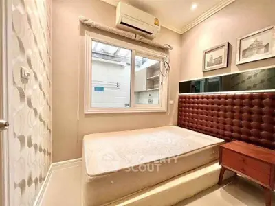 Cozy bedroom with stylish decor and natural light, featuring a comfortable bed and elegant wall art.