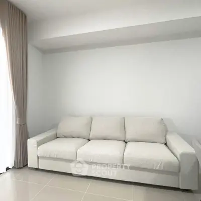 Spacious living room with modern white sofa and natural light