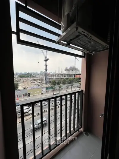 Urban balcony with city view and construction site, ideal for modern living.