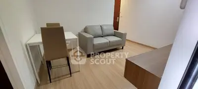 Cozy living room with modern sofa and dining area in a minimalist apartment.