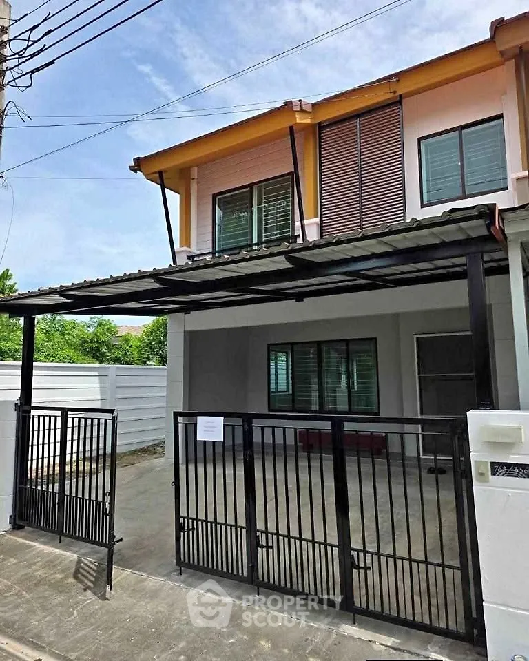 Modern two-story house with gated driveway and sleek exterior design.