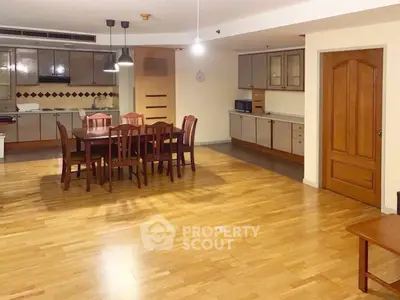 Spacious open-plan kitchen and dining area with wooden flooring and modern lighting.