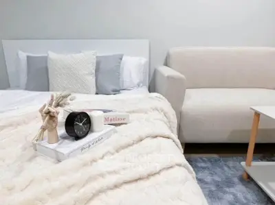 Cozy bedroom with plush bedding and modern decor, perfect for relaxation.