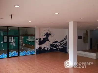 Spacious modern lobby with artistic wave mural and tiled flooring